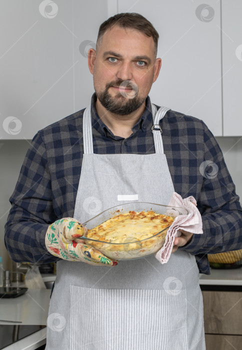 Скачать Портрет брюнета средних лет на кухне в фартуке фотосток Ozero