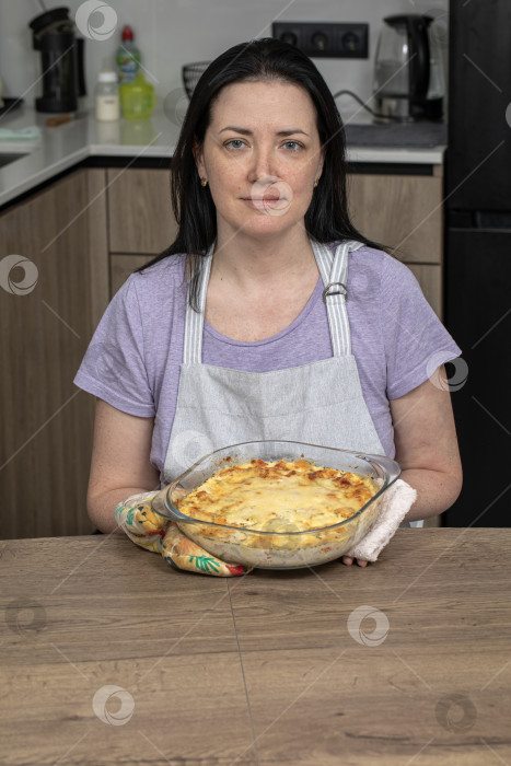 Скачать Портрет брюнетки средних лет на кухне в фартуке фотосток Ozero