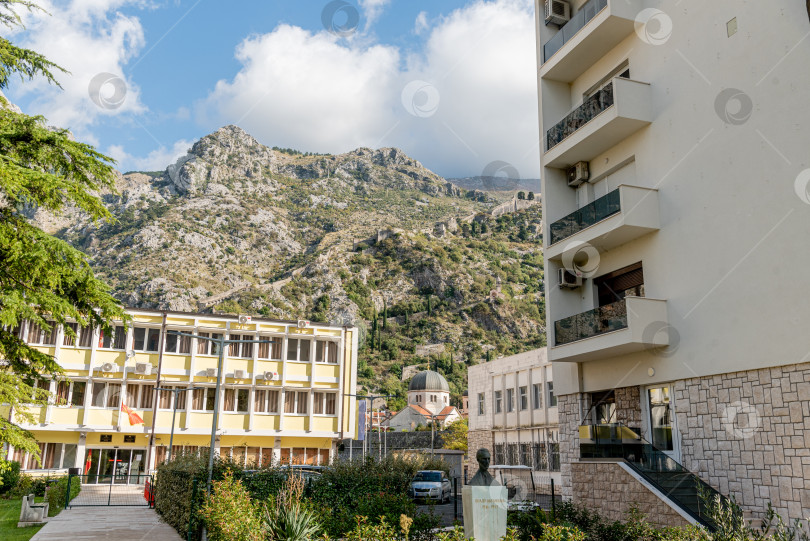 Скачать Котор, Черногория, 26 октября 2025 года, Жилое здание и храм в горах фотосток Ozero