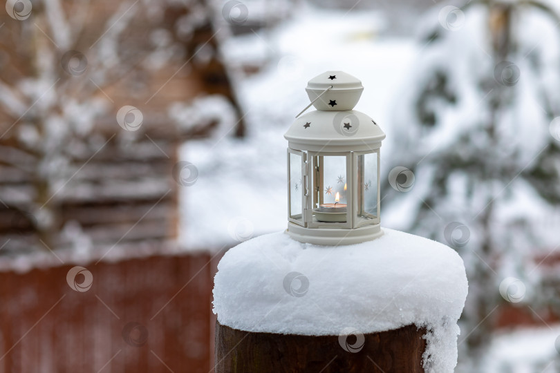 Скачать Винтажный декоративный светильник с горящей свечой в зимнем дворике. Украшение зимней вечеринки. фотосток Ozero