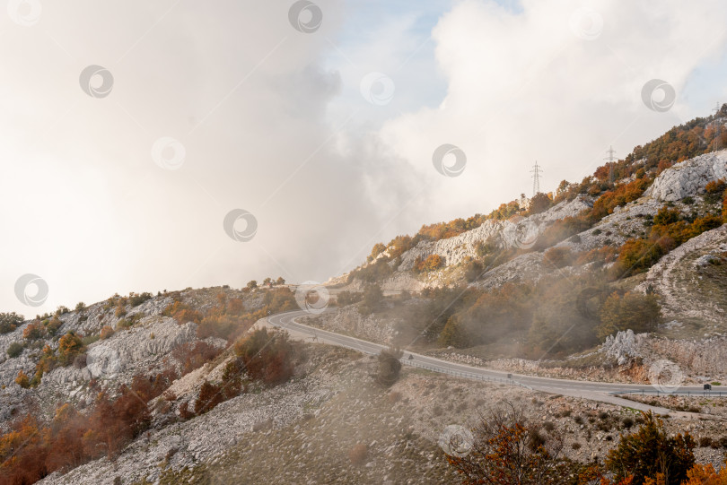 Скачать Серпантин горной автомобильной дороги на вершине горы Ловчен в пасмурный туманный осенний день фотосток Ozero