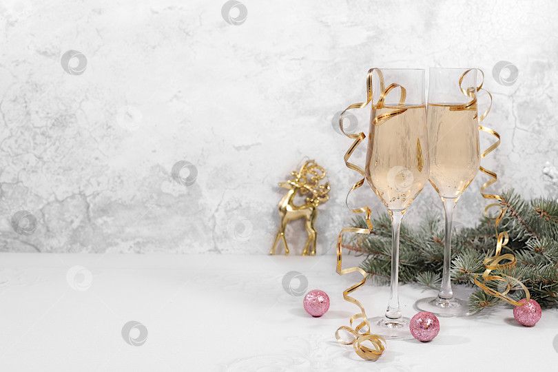Скачать Два бокала шампанского на элегантном праздничном фоне с еловыми ветками и украшениями - концепция кануна Рождества. Рождественский и новогодний макет для оформления и демонстрации продукции. с Новым Годом фотосток Ozero