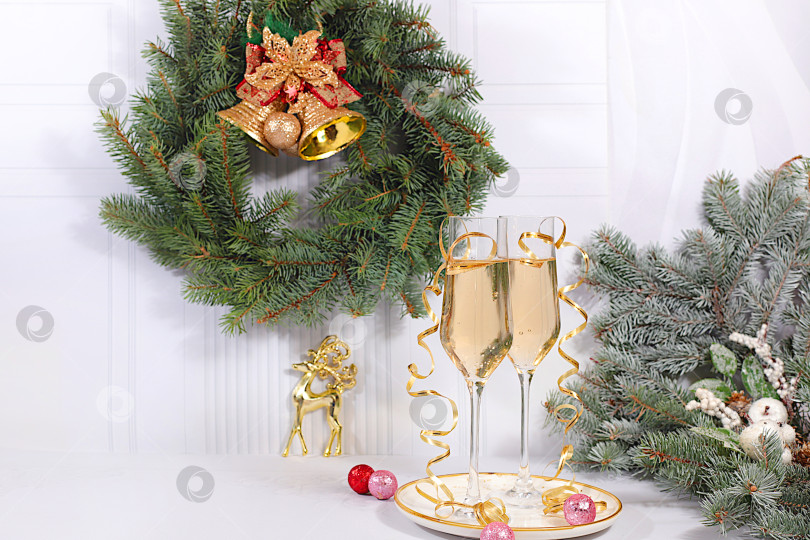 Скачать Два бокала шампанского на элегантном праздничном фоне с еловыми ветками и украшениями - концепция кануна Рождества. Рождественский и новогодний макет для оформления и демонстрации продукции. с Новым Годом фотосток Ozero