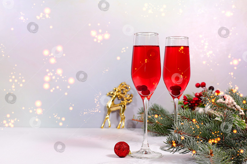 Скачать Рождественский алкогольный коктейль с красным шампанским "Мимоза" и клюквой в бокалах на праздничном фоне с еловыми ветками и украшениями, концепция бара и сочельника, алкогольные напитки на вечеринке фотосток Ozero