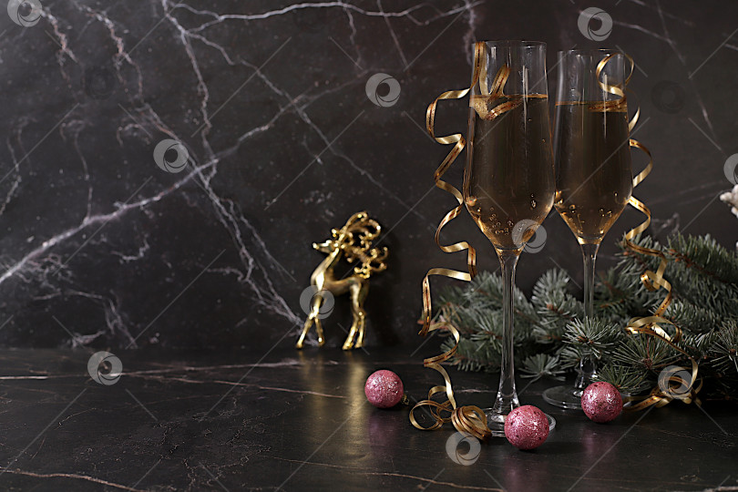 Скачать с Новым Годом. Два бокала шампанского на праздничном фоне еловых веток и украшений - концепция кануна Рождества. Рождественский и новогодний макет для дизайна и продаж продукции фотосток Ozero