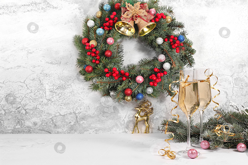 Скачать с Новым Годом. Два бокала шампанского на праздничном фоне еловых веток и украшений - концепция кануна Рождества. Рождественский и новогодний макет для дизайна и продаж продукции фотосток Ozero