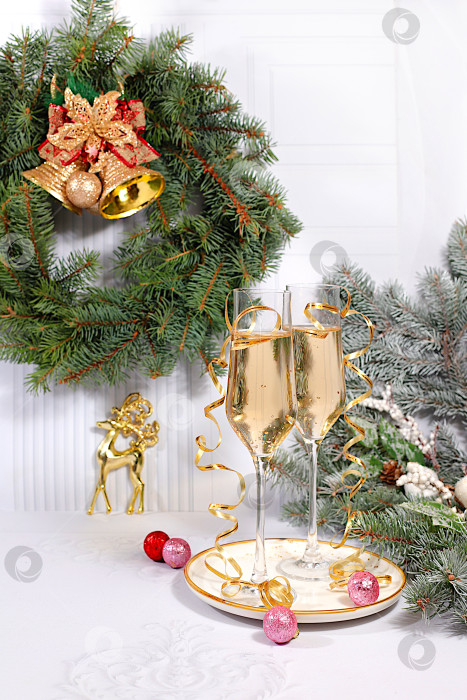 Скачать Два бокала шампанского на элегантном праздничном фоне с еловыми ветками и украшениями - концепция кануна Рождества. Рождественский и новогодний макет для оформления и демонстрации продукции. с Новым Годом фотосток Ozero