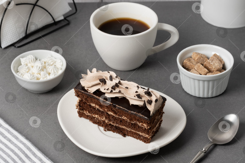 Скачать Вкусный шоколадный торт, подаваемый с кофе, кусочками сахара и безе на сером столе фотосток Ozero
