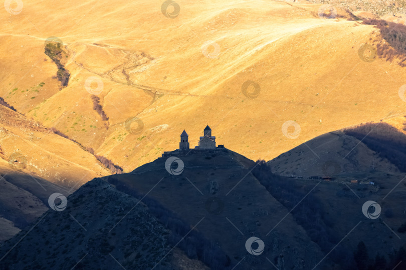 Скачать Церковь Гергети, Грузия, на закате. Вид издалека. фотосток Ozero