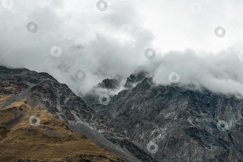 Скачать Таинственный пейзаж с красочными осенними горами в низких облаках. фотосток Ozero