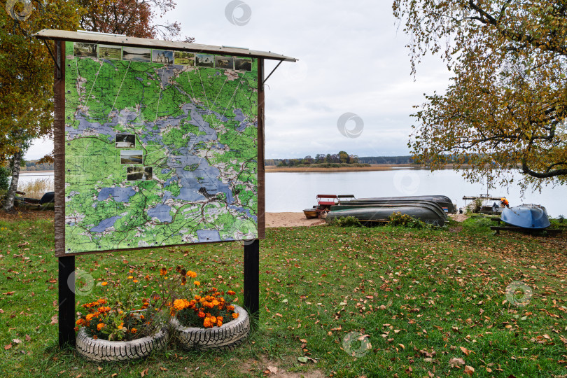 Скачать Большая информационная карта Озера Селигер на фоне природного осеннего пейзажа. с озером и лодками на берегу. фотосток Ozero