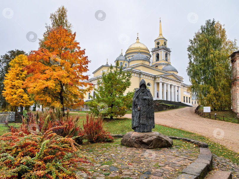 Скачать Памятник Нилу Столобенскому на фоне главного собора Нило-Столбенского монастыря (Нилова пустынь). Яркая золотая осень и атмосфера умиротворения. фотосток Ozero