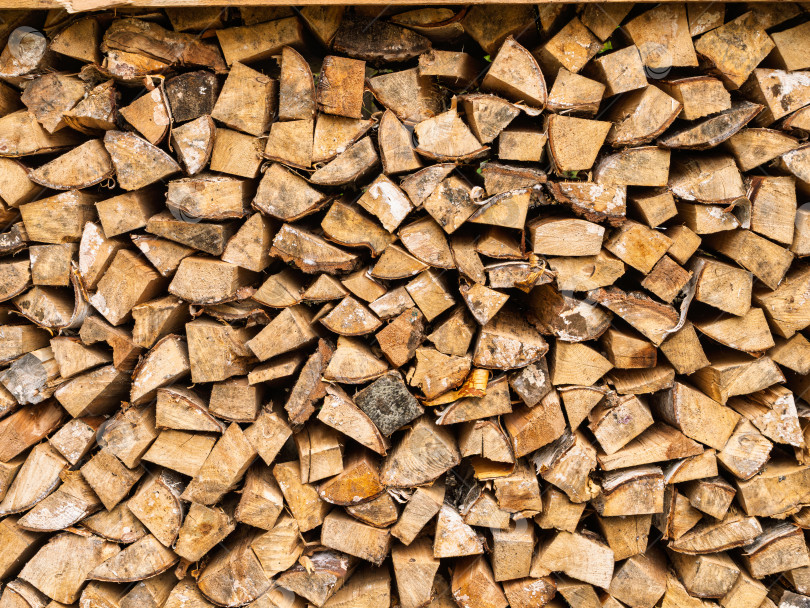 Скачать Крупный план текстуры аккуратно сложенных колотых дров для отопления. Природный фон и узор березовой древесины. фотосток Ozero