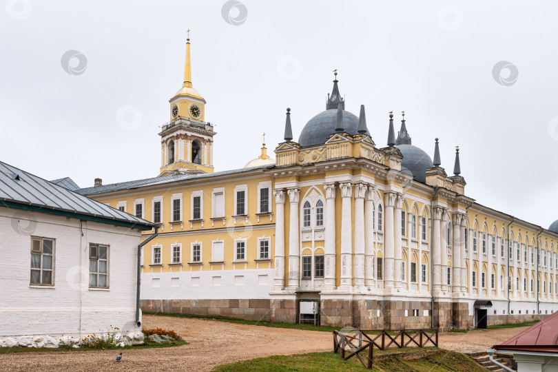 Скачать Панорамный вид на Братский корпус с часовой колокольней Нило-Столбенского монастыря (Нилова пустынь). Архитектурный комплекс в стиле классицизма на фоне пасмурного осеннего неба. фотосток Ozero