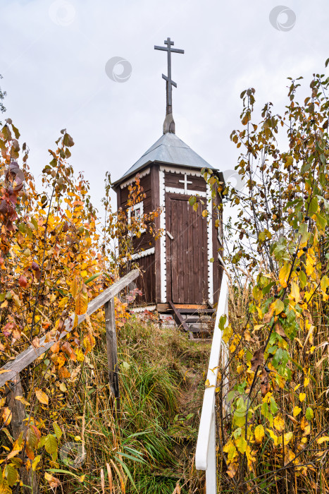 Скачать Деревянная часовня с крестом на холме. Осенний пейзаж и лестница сквозь заросли. фотосток Ozero