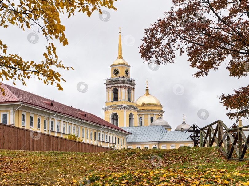Скачать Панорамный вид на колокольню и фрагмент Преображенского собора Нило-Столбенского монастыря (Нилова пустынь). Братский корпус с красной крышей на фоне осенней листвы. фотосток Ozero