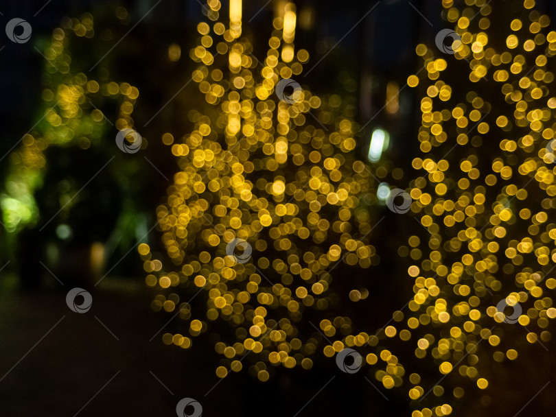 Скачать Атмосферный ночной снимок с эффектом боке с золотисто-желтыми кругами света на темном фоне фотосток Ozero