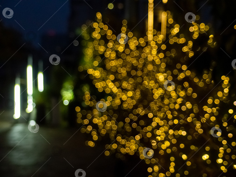 Скачать Атмосферный ночной снимок с эффектом боке с золотисто-желтыми кругами света на темном фоне фотосток Ozero