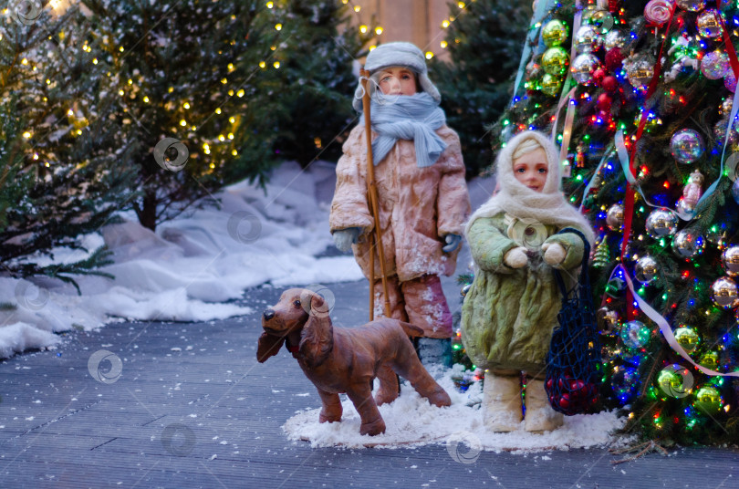 Скачать Новогодняя композиция с куклами и декоративной собакой у елки фотосток Ozero