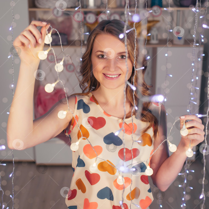 Скачать Молодая красивая женщина с гирляндами улыбается в День Святого Валентина фотосток Ozero