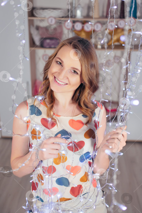 Скачать Молодая женщина с гирляндами улыбается в День Святого Валентина фотосток Ozero