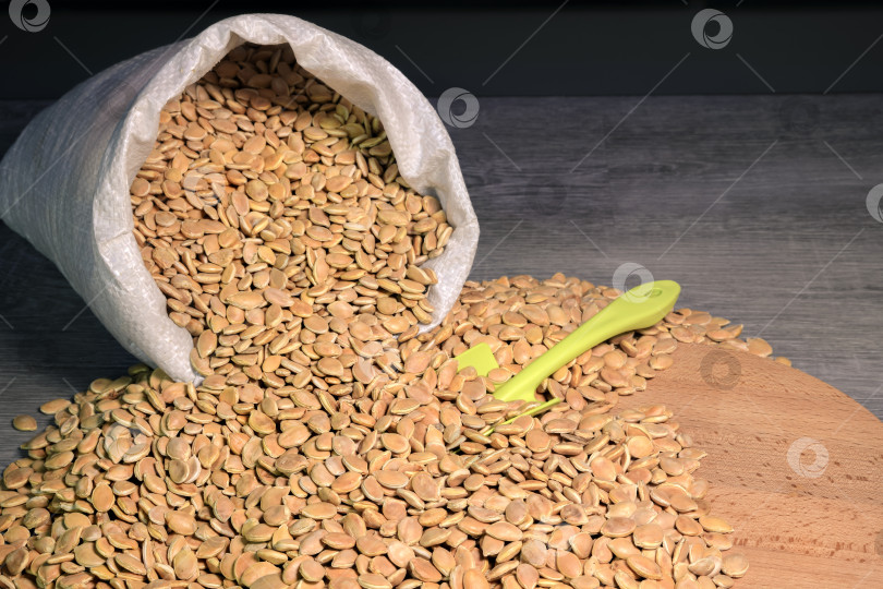 Скачать Тыквенные семечки высыпаем из пакета на доску.  фотосток Ozero