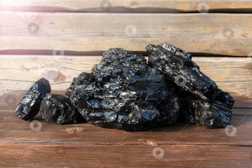 Скачать Кусочки угля на деревянной поверхности. фотосток Ozero