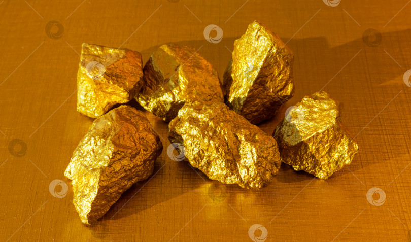 Скачать Золотые самородки на позолоченном фоне.  фотосток Ozero
