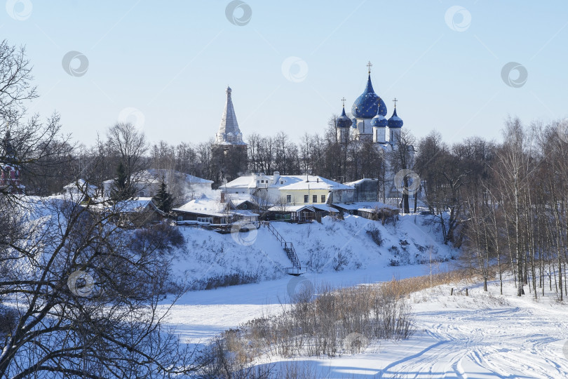 Скачать Зимний пейзаж Суздаля. Вид на реку Каменку с пойменным лугом, остатками крепостных валов и Рождественским собором Суздальского кремля на заднем плане. фотосток Ozero