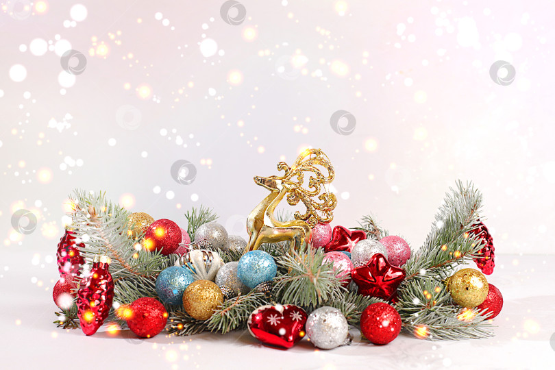 Скачать С Новым годом. Праздничная зимняя открытка с рождественскими украшениями на заснеженных еловых ветках, концепция Сочельника, новогодний фон с огнями и украшениями, концепция Сочельника. фотосток Ozero