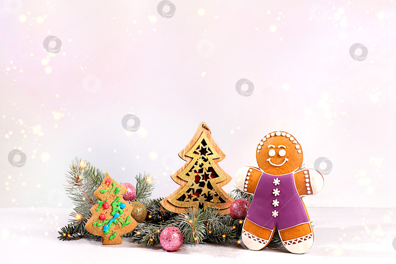 Скачать Праздничная зимняя поздравительная открытка и баннер на экране, новогодние пряники и рождественские украшения на заснеженных еловых ветках, рождественский и новогодний фон с подсветкой и украшениями фотосток Ozero