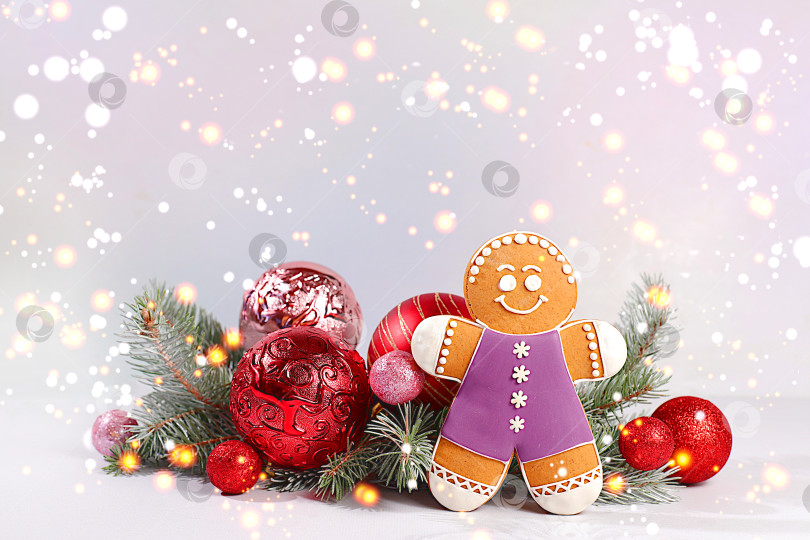 Скачать с Новым Годом. Праздничная зимняя поздравительная открытка, пряники и рождественские украшения на заснеженных еловых ветках, концепция Сочельника, новогодний фон с огнями и украшениями фотосток Ozero