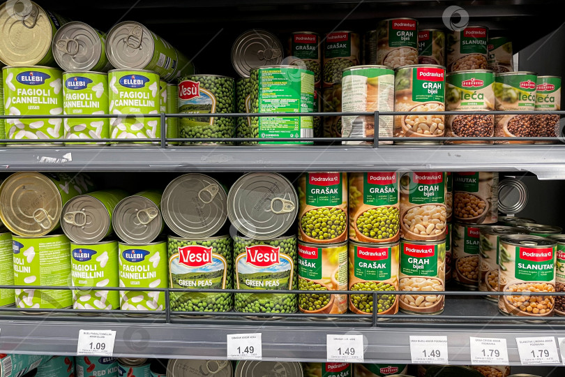 Скачать Бар, Черногория, 30 октября 2025 года, банка консервированного горошка и кукурузы на полке супермаркета фотосток Ozero