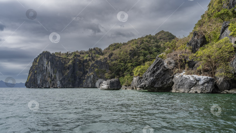 Скачать Живописные острова в океане. Крутые склоны и валуны над бирюзовой водой. фотосток Ozero