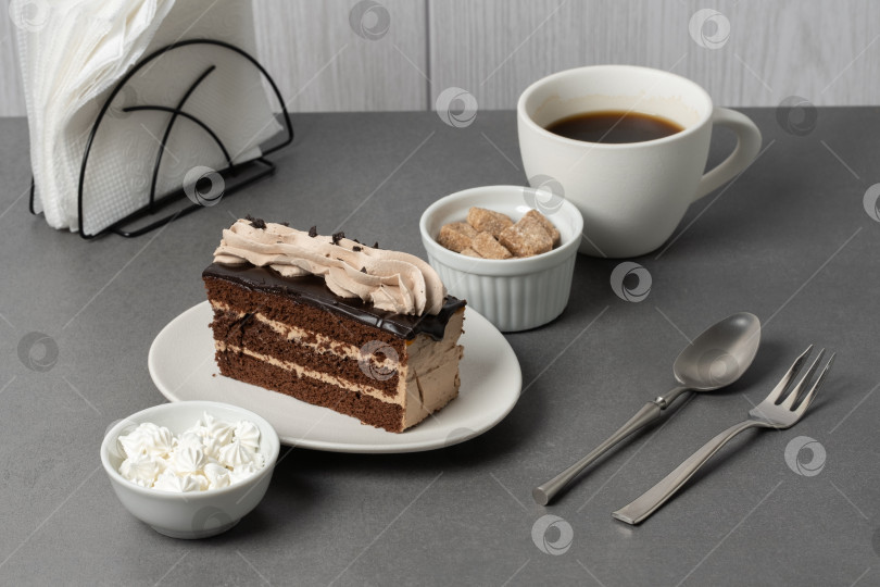 Скачать Вкусный шоколадный торт, подаваемый с кофе, кусочками сахара и безе на сером столе фотосток Ozero