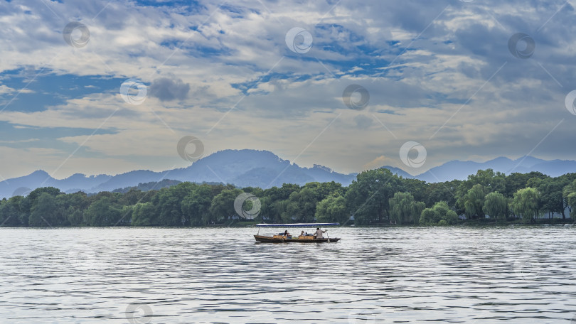 Скачать Лодка плывет по спокойному и живописному озеру фотосток Ozero