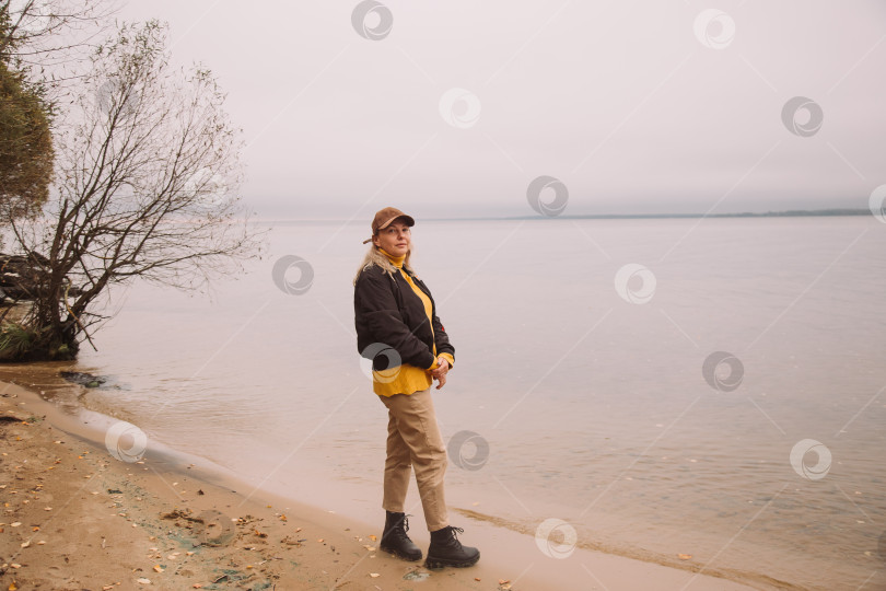 Скачать портрет женщины в осеннем наряде, стоящей на краю и смотрящей на туманное озеро фотосток Ozero