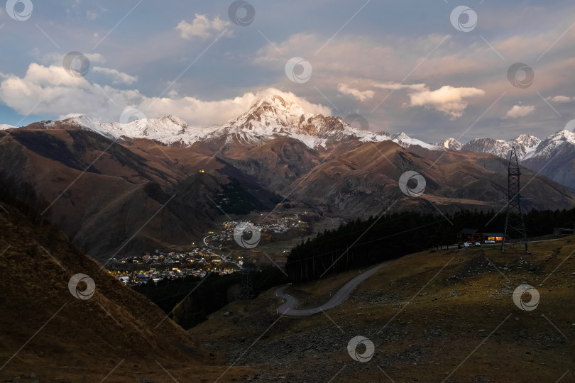 Скачать Вечерний вид на деревню у подножия горы. Грузия. фотосток Ozero