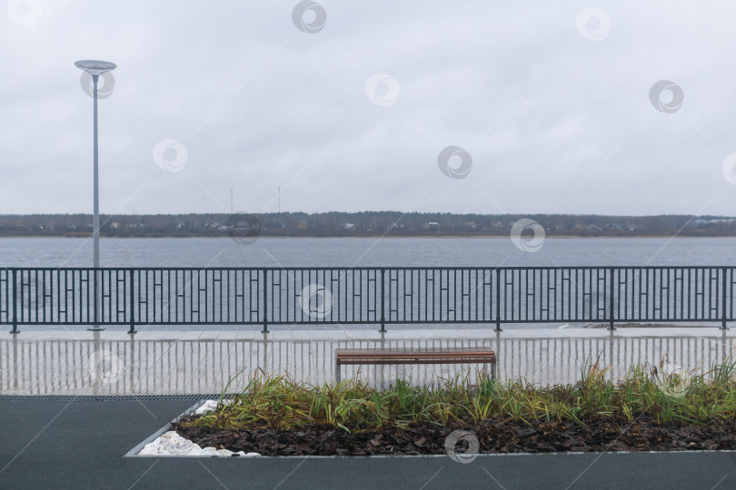 Скачать Скамейка на набережной реки в пасмурную погоду. фотосток Ozero