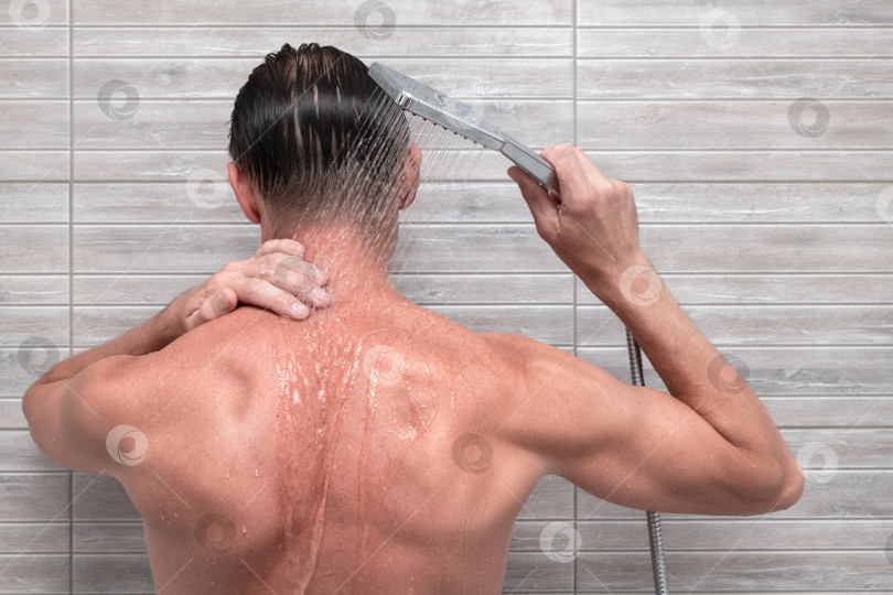 Скачать Мужчина в ванной под душем.  фотосток Ozero