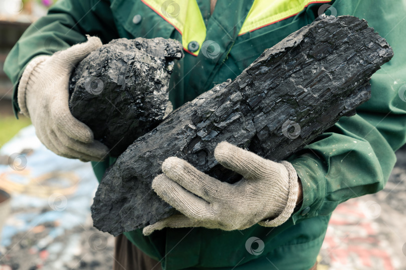 Скачать Кусок угля в руках мужчины. фотосток Ozero