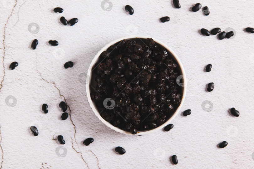 Скачать Крупный план ферментированных черных бобов души в миске на столе вид сверху фотосток Ozero