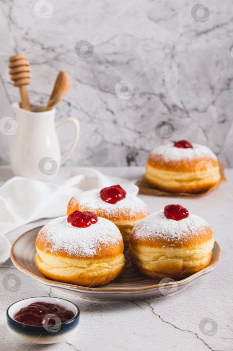 Скачать Сладкие пончики в сахарной пудре с джемом на тарелке на столе, вид сверху фотосток Ozero