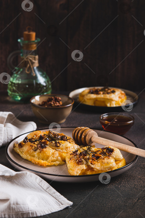 Скачать Запеченная тыква с сыром бри, орехами, розмарином и медом на тарелке на столе, вид сверху фотосток Ozero