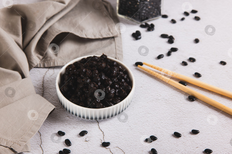 Скачать Азиатская ферментированная черная фасоль на тарелке на столе фотосток Ozero