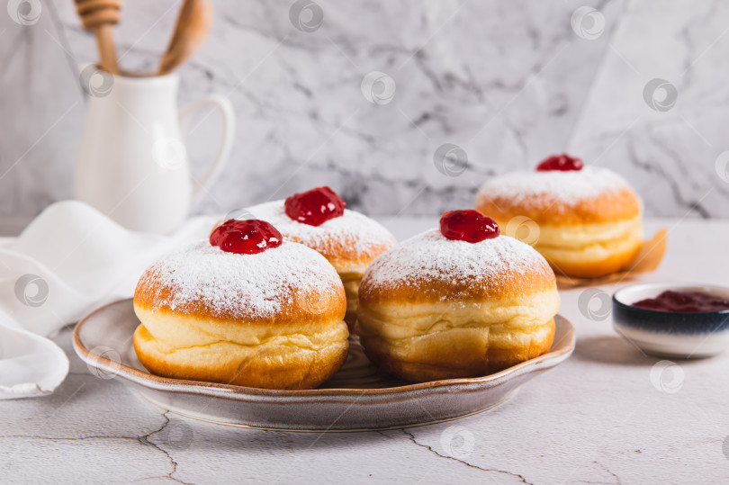 Скачать Сладкие пончики в сахарной пудре с джемом на тарелке на столе фотосток Ozero