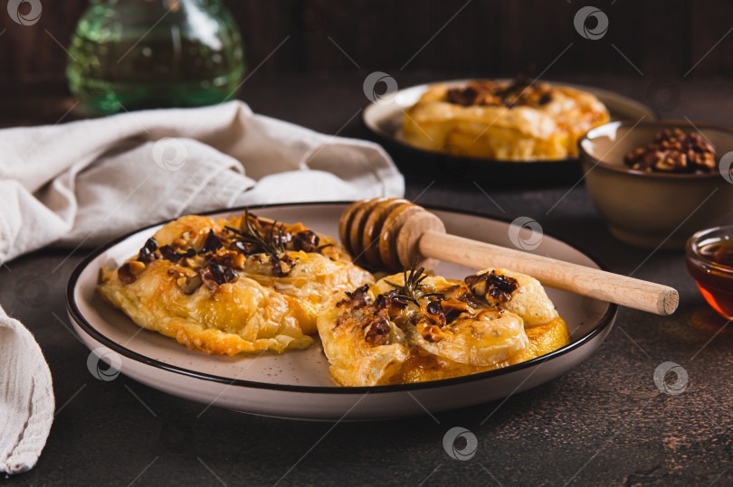 Скачать Запеченная тыква с сыром бри, орехами, розмарином и медом на тарелке на столе фотосток Ozero