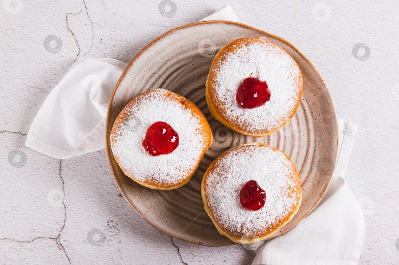 Скачать Крупный план сладких пончиков в сахарной пудре с джемом на тарелке на столе вид сверху фотосток Ozero