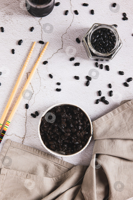 Скачать Азиатские ферментированные черные бобы на тарелке на столешнице в вертикальном положении фотосток Ozero