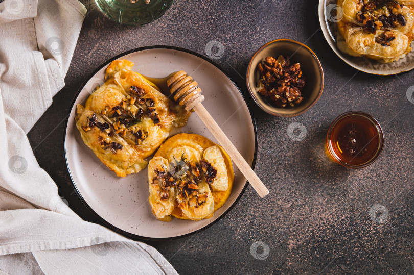 Скачать Запеченная тыква с сыром бри, орехами, розмарином и медом на тарелке на столе вид сверху фотосток Ozero